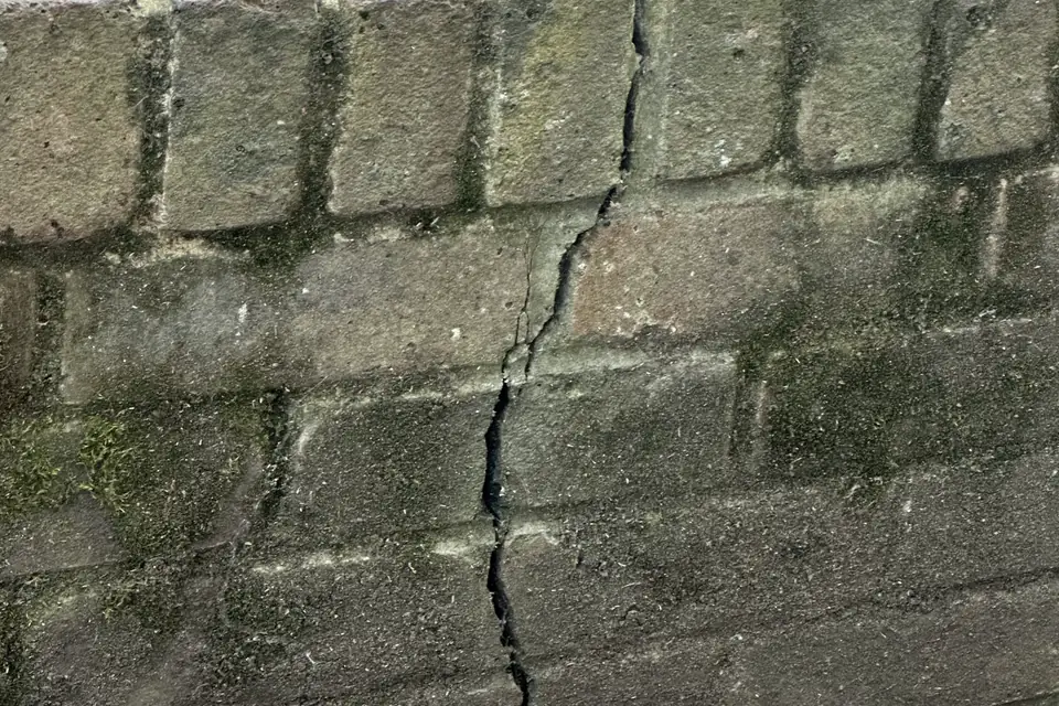 Short block retaining wall with a vertical crack running down through several courses