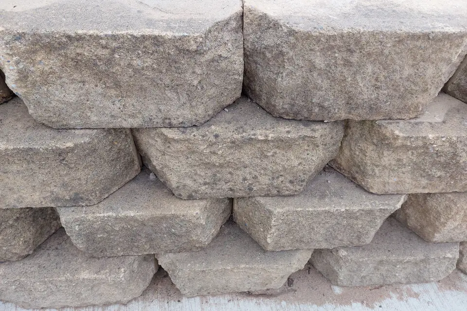 Rows of tan segmental concrete blocks forming the face of a retaining wall